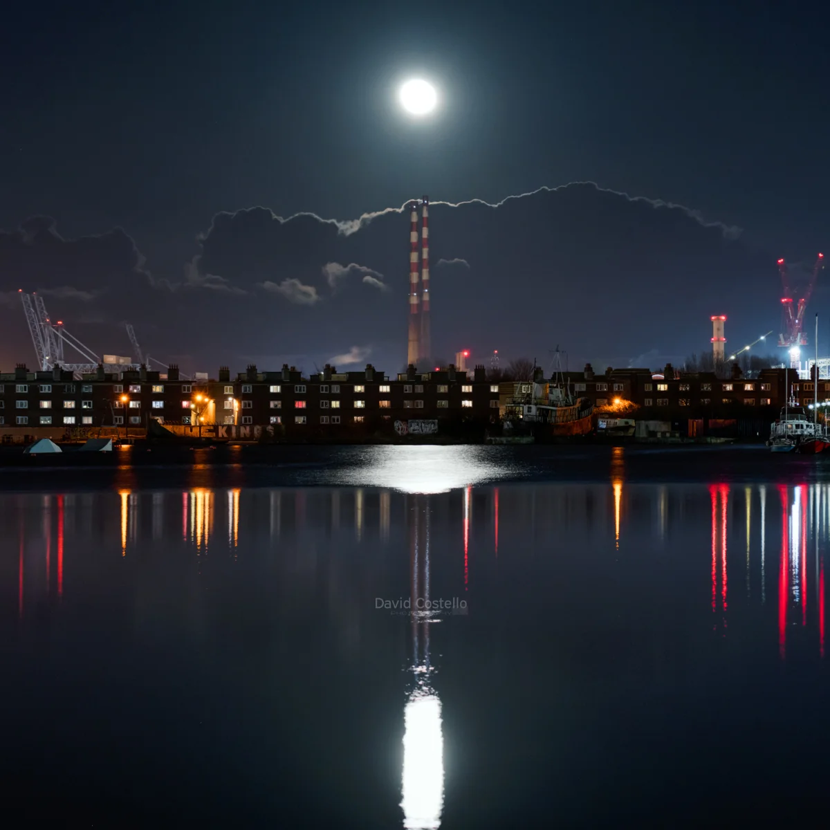 The Full Moon rises above Poolbeg Lighthouse on a beautiful crisp spring evening along the Great South Wall in Dublin.