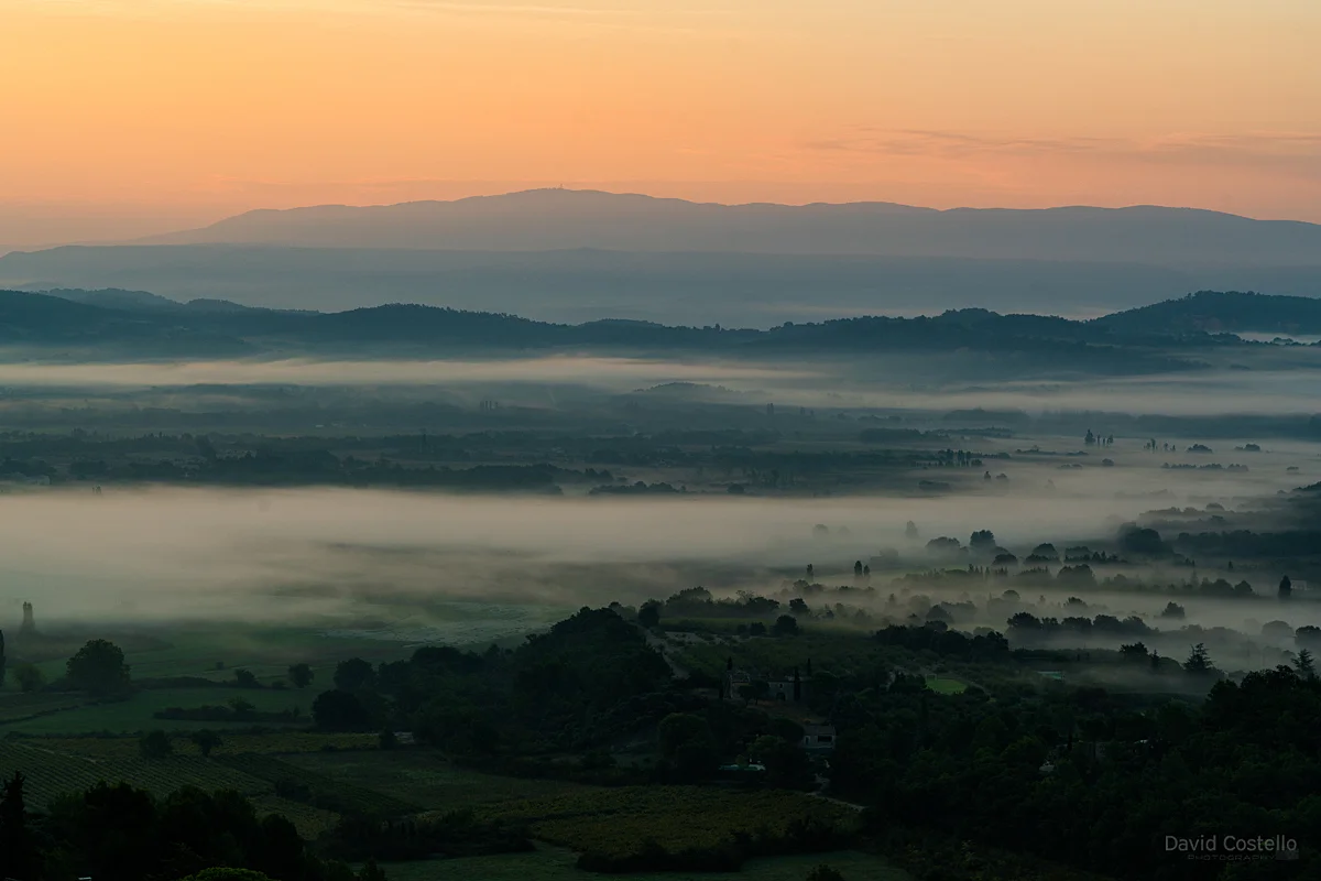Looking over valleys and vineyards towards Roussillon at dawn on a beautiful misty morning from Gordes in Cote d'Azur.
