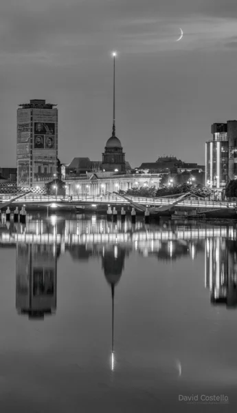 The Custom House, Liberty Hall, The Spire and a Crescent Moon all reflect in a perfectly calm river Liffey.
