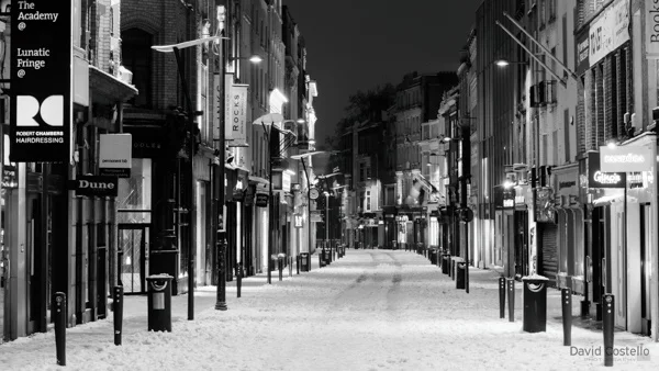Grafton Street empty of people and covered in snow on a winter night.