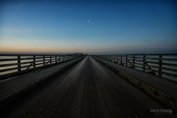 Sunrise at the Wooden Bridge in Clontarf as the half moon lines up centre of the bridge.